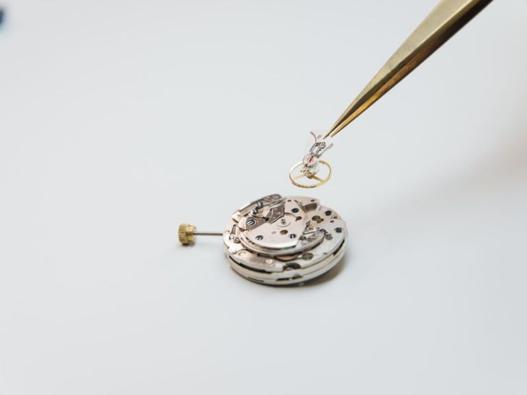 Calibre de reloj desmontado con pinzas